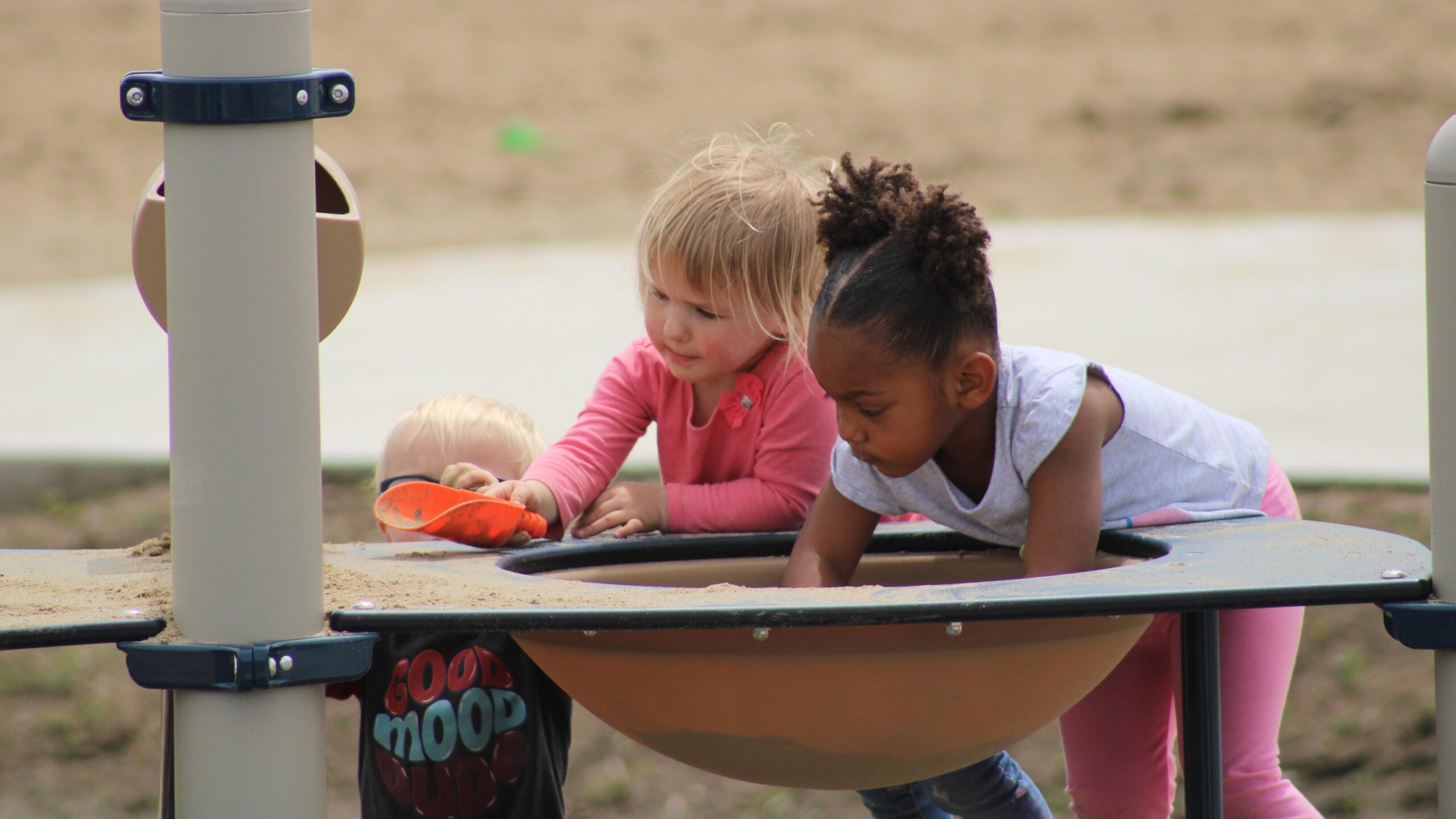 Two children playing at a sensory sand table at Athene North Shore Recreation Area.